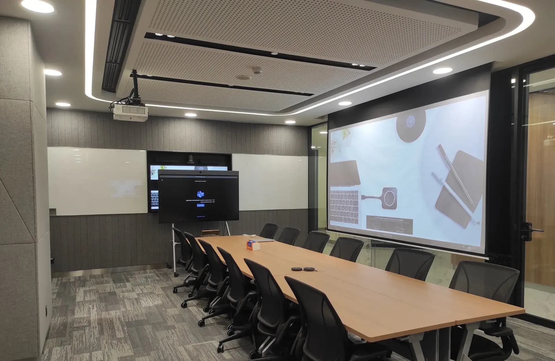Ruang rapat korporat dengan display Microsoft Teams Rooms, presentasi nirkabel, proyektor, dan plafon akustik — dikerjakan GVM di Indonesia